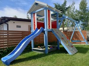 a playset with a slide in a yard at Camping Mauritius in Mielno