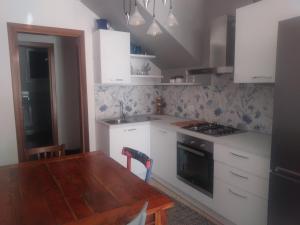 a kitchen with white cabinets and a wooden table at Oltre il Poggio del Sole in Marostica