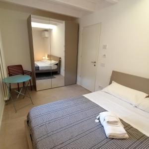 a bedroom with a bed and a table and a mirror at New Marina Apartments in Torri del Benaco