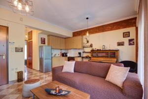 a living room with a couch and a kitchen at East City Living Apt - Netflix, Vesta Philoxenia in Thessaloniki