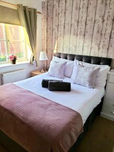 a bedroom with a large bed with a large headboard at Larkspur House in West midlands in Bedworth