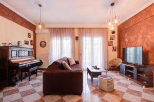 a living room with a couch and a piano at East City Living Apt - Netflix, Vesta Philoxenia in Thessaloniki
