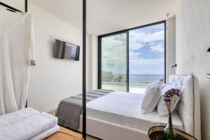 a bedroom with a view of the ocean at 'S CAVE VILLAS SEASIDE KARYSTOS in Karistos +53 photos