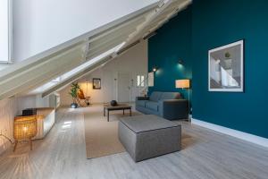 ein Wohnzimmer mit einem Sofa und einer blauen Wand in der Unterkunft Ando Living - Abrantes 10 House in Lissabon