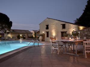 un patio avec une table et des chaises à côté d'une piscine dans l'établissement Razis Apartments, à Tsilivi