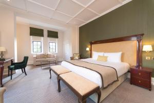 een grote slaapkamer met een groot bed en een bureau bij The Elvetham Hotel in Farnborough