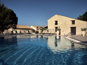 a large swimming pool with chairs and a building at Razis Apartments in Tsilivi