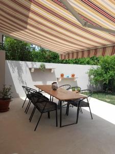 a wooden table and chairs under a patio umbrella at Apartman Family Čović in Opuzen
