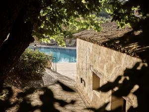 a stone building with a pool in the background at Razis Apartments in Tsilivi