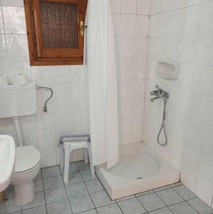 a bathroom with a tub and a toilet and a sink at Andreas Apartments in Agios Georgios Pagon