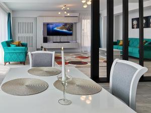 a living room with a white table with a candle on it at Ada Luxury Apartments 57 in Mamaia