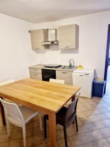 cocina con mesa de madera y algunas sillas en BORGO VOLCIANO GARDA LAKE APP.2 en Roe