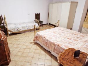Habitación con 2 camas y mesa. en BORGO VOLCIANO GARDA LAKE APP.2 en Roe