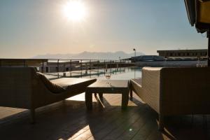 un patio con tavolo, sedie e vista sull'acqua di Blu Hotel a Pontecagnano