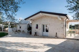 a small white brick house with a patio at Il Trullo delle Due Lune in Noci