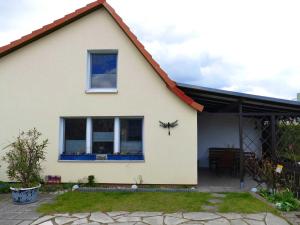 Warenshof的住宿－Ferienhaus "Libelle" Objekt ID 12111-6，白色的房子,设有窗户和庭院