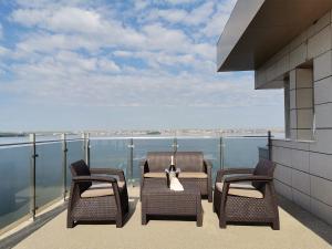 a balcony with three chairs and a view of the water at Ada Luxury Apartments 57 in Mamaia