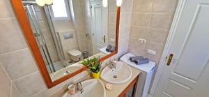 a bathroom with two sinks and a shower and a mirror at CASA LOTTA in Costa Calma +17 photos