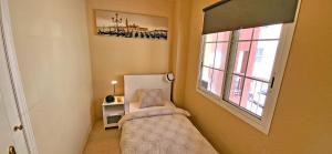 a small bedroom with a bed and a window at CASA LOTTA in Costa Calma