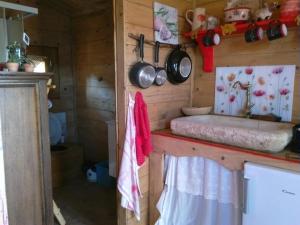 a kitchen with a counter with pots and pans on the wall at Chalet sur Pilotis Ane'ita de l'Arbenquens in La Mure