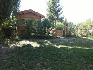 a house in a yard with a fence at Chalet sur Pilotis Ane'ita de l'Arbenquens in La Mure
