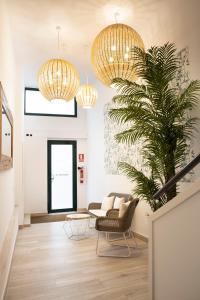 un soggiorno con lampadari a braccio dorati e una pianta di Urban Suites Sitges Apartments a Sitges
