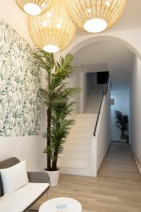 a living room with stairs and a palm tree at Urban Suites Sitges Apartments in Sitges