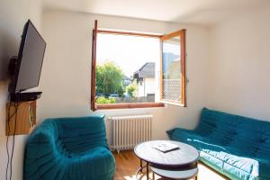 ein Wohnzimmer mit 2 blauen Sofas und einem Tisch in der Unterkunft Maison proche lac, vélos, parking in Sévrier