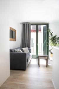 a living room with a couch and a balcony at Urban Suites Sitges Apartments in Sitges
