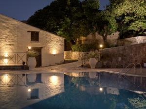 une villa avec une piscine la nuit dans l'établissement Razis Apartments, à Tsilivi