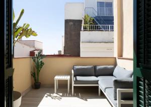 a living room with a couch on a balcony at Urban Suites Sitges Apartments in Sitges