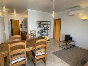 - une salle à manger avec une table et des chaises en bois dans l'établissement Beachfront T1, à Armação de Pêra