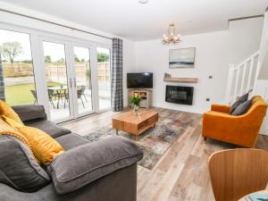 a living room with a couch and a table at 15 Parc Delfryn in Brynteg