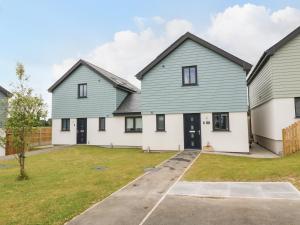 a group of three houses with a driveway at 15 Parc Delfryn in Brynteg