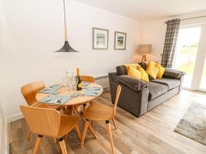 a living room with a table and a couch at 15 Parc Delfryn in Brynteg