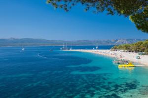 a beach with people and boats in the water at Apartment CasArosa in Bol