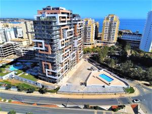 - une vue aérienne sur un grand bâtiment avec une piscine dans l'établissement Elite Residense a 150 mts Praia da Rocha, à Portimão