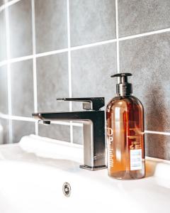 a soap dispenser sitting on a sink in a bathroom at Byggmästare Villan in Motala