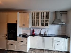a kitchen with white cabinets and black counter tops at Wohnen2a in Harsewinkel