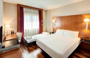 Cette chambre comprend un grand lit blanc et un bureau. dans l'établissement Sercotel AB Rivas, à Rivas-Vaciamadrid