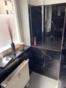 a bathroom with a black tiled floor and a sink at City Apartment #2 bei der Porzellan Manufaktur in Meißen