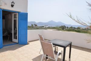 a table and a chair sitting on a patio at Papikinou Studios in Adamantas