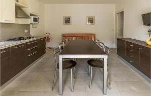 Stunning Apartment In Cavallino-treporti With Outdoor Swimming Pool في كافالّينو تريبورتي: مطبخ فيه طاولة وكراسي