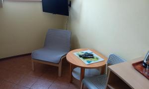 einen Tisch mit 2 Stühlen und einen Tisch mit einem blauen Stuhl in der Unterkunft Romir Pokoje Bardzo Gościnne in Sztutowo