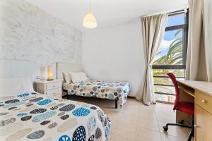 sypialnia z 2 łóżkami, biurkiem i biurkiem w obiekcie Villa Paula Costa Teguise w Costa Teguise +37 zdjęć