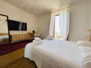 1 dormitorio con 1 cama blanca grande y toallas. en Sdraiati Apartments - Bed & Breakfast - Pollica, en Pollica