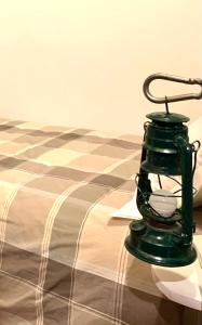 Enjoy Ledro B&B في ليدرو: وجود فانوس أخضر فوق السرير