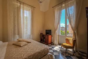 1 dormitorio con 1 cama, TV y ventana en Relais Palazzo Vaglio, en Nardò