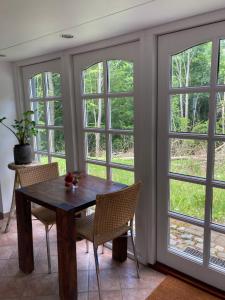 a table and chairs in a room with windows at Skovlyset’s B&B in Juelsminde