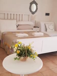 een slaapkamer met een bed met een tafel met bloemen erop bij Villaggio Imbesi in Villa San Giovanni